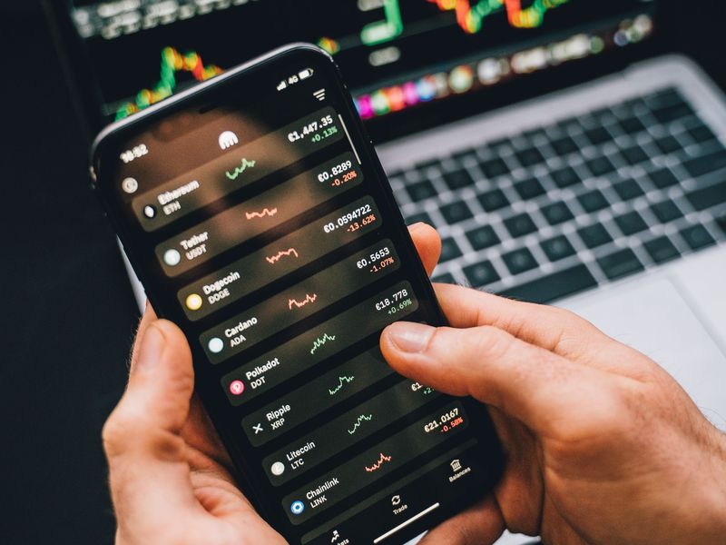 Trader checks crypto prices on a phone as Japan's 20% crypto tax plan advances