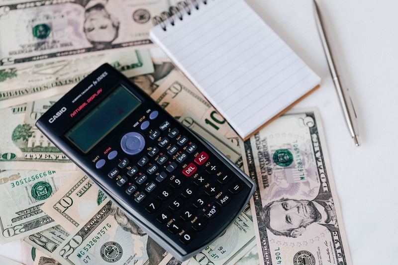 US dollar bills next to a calculator, representing USDT stablecoin balances converting to fiat currency