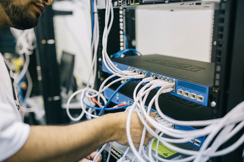 Technician working on GPU server racks in an AI data center, the capacity behind AI compute futures