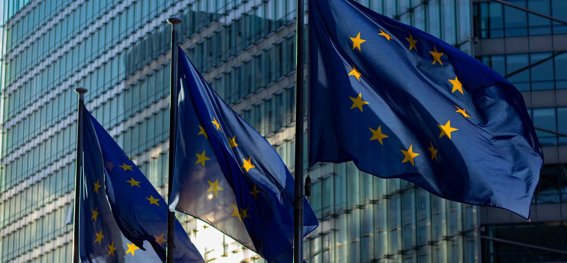 EU flags at the European Commission building illustrating the first published MiCA penalty